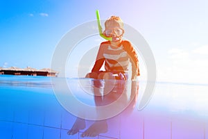 Little boy swimming diving into the pool at tropical beach