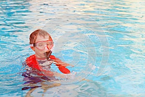 Little boy swimming with mask in outdoor pool