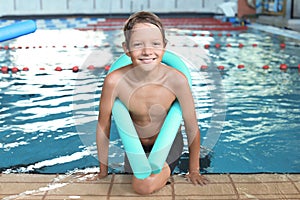 Little boy with swimming noodle