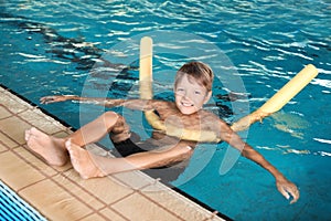 Little boy with swimming noodle