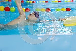 Little boy swimming in pool, kid in glass learning swim by crawls . Sport and hardening. Healthy mind. children`s wellness center