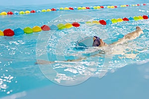 Little boy swimming in pool, kid in glass learning swim by crawls . Sport and hardening. Healthy mind. children`s wellness center