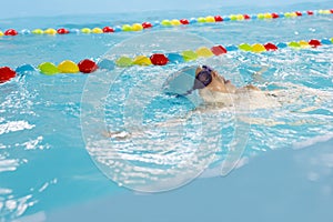 Little boy swimming in pool, kid in glass learning swim by crawls . Sport and hardening. Healthy mind. children`s wellness center