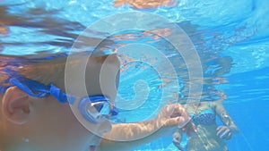 Little Boy Swimming in the Pool between Relatives