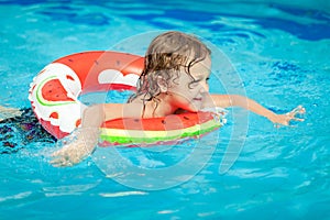 Little boy in the swimming pool with rubber ring