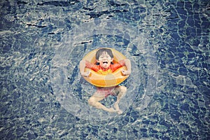 Little boy in the swimming pool with rubber ring