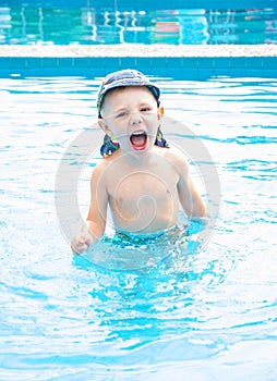 Little boy swims, cheerful child jumping in the pool in the circle, open-air swimming pool,