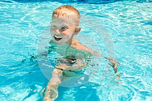 Little boy swims in pool