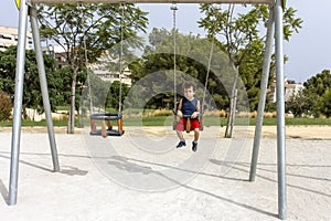 Little Boy Swinging Alone in Sunny Park