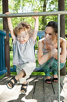 Little boy swinging on monkey bars