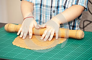 Boy swinging a rolling pin cookie dough