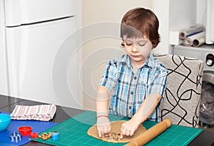 Boy swinging a rolling pin cookie dough
