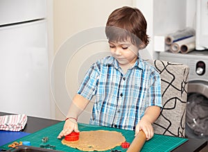 Boy swinging a rolling pin cookie dough