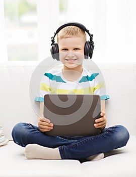 Little boy with tablet pc and headphones at home