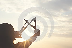 Little boy takes aim with his slingshot to hit his target successfully