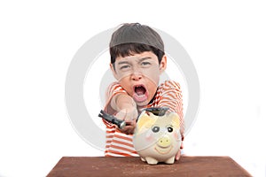 Little boy taking hammer thinking and trying to broke piggy bank