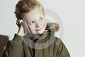 Little boy talking on the cellphone. modern child in winter coat. fashion kids.children