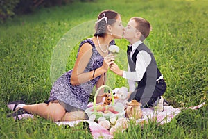 Little boy and teen age girl having picnic outdoors