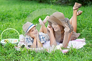Little boy and teen age girl having picnic outdoors