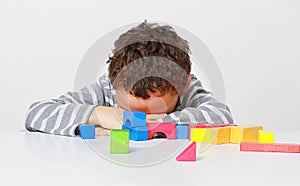 Little boy testing his creativity by building towers with toy building blocks