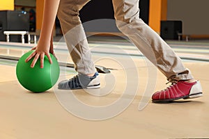 Little boy throwing ball in bowling club