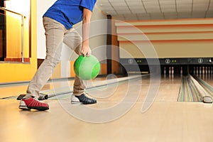 Little boy throwing ball in bowling club. Space for text