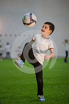 A little boy throwing ball on the field playing football with other kids