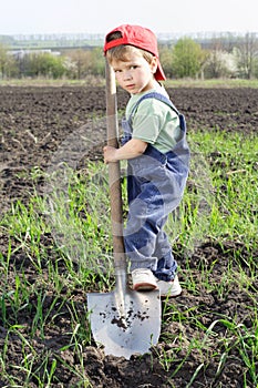 Little boy to dig on field