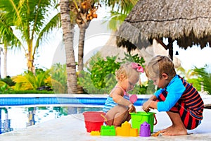 Little boy and toddler girl playing at beach