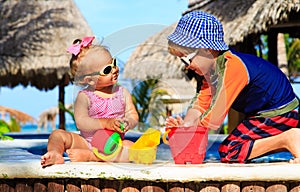 Little boy and toddler girl playing in swimming