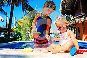 Little boy and toddler girl playing in swimming