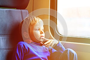 Little boy travel by train looking at the window