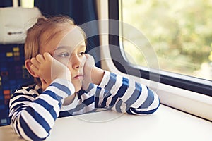 Little boy is traveling on the train. Kid travels on a train. Cute child looking out the train window