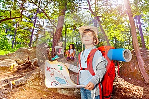 Little boy with treasure map in the forest game