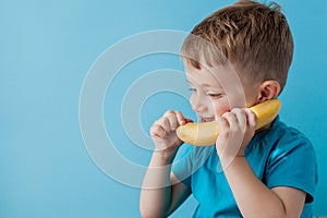 Little Boy tries to speak by means of a banana instead of phone