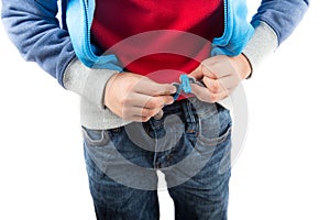 Little boy trying cloth his zipper on sweater close up