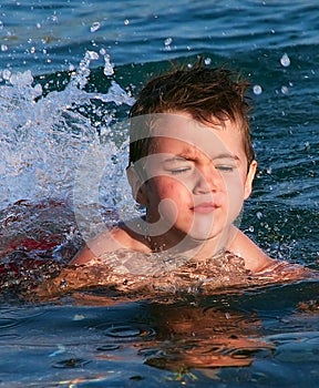 Little boy trying to swim for first time during Summer vacation