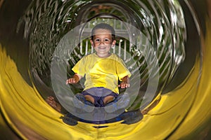 Little boy in tube slide