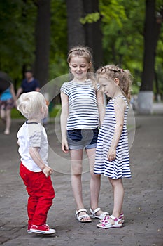 Little boy and two older cousins, meeting in the summer park