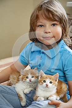 Little boy with two red kitten in hands close up. Best friends. Interaction of children with pets