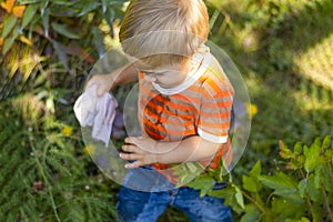 A little boy of two years running on the grass on a summer day.  Pretty baby in wet clothes. Bully. Close-up.