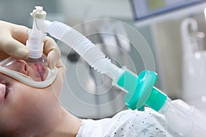 A little boy under anesthesia. Breathing mask on the face. Withdrawal from anesthesia. Concept of health care and life saving.