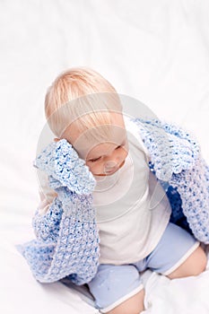 Little boy under blanket on the bed