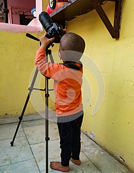 Little boy understanding how to operate DSLR Camera, Portrait of a sweet little boy with a large DSLR camera