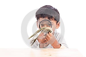 Little boy use magnifier looking money