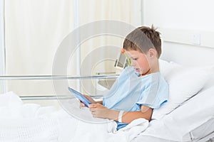Little boy using digital tablet in hospital