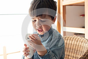 Little boy using a digital thermometer