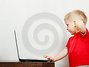 Little boy using laptop computer playing games