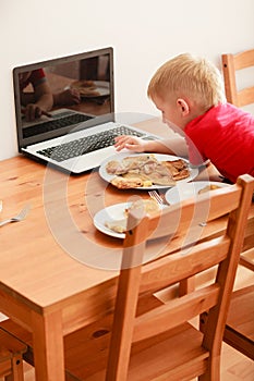 Little boy using laptop computer playing games