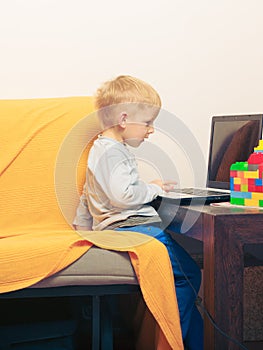 Little boy using laptop computer playing games
